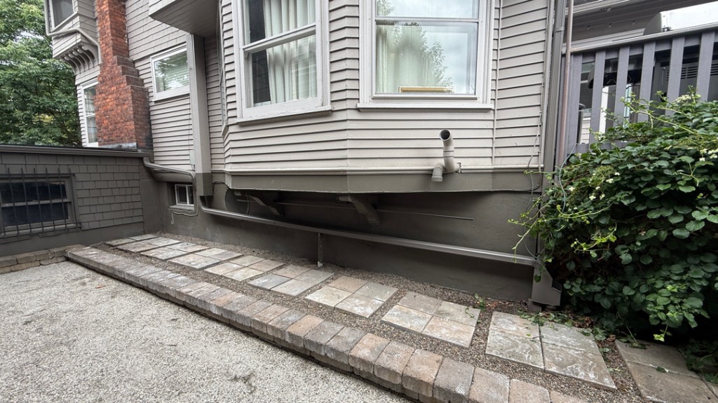 Downspout and drainage setup directing water away from a residential foundation