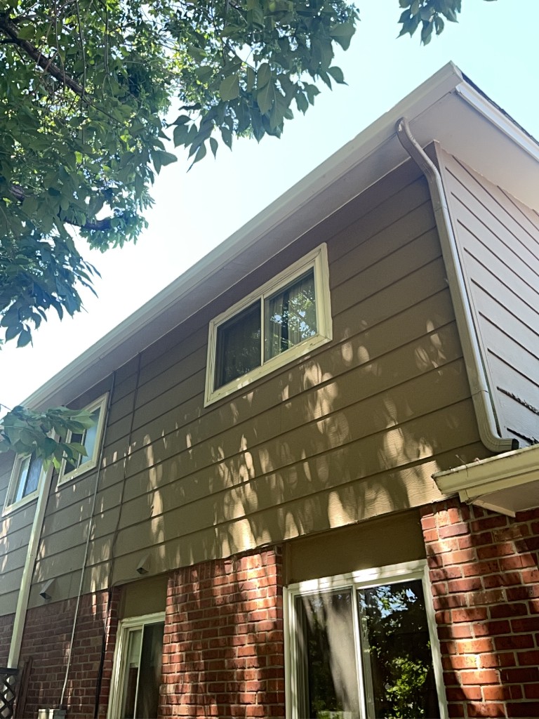 White gutters and downspout installed on a Denver-area brick and siding home